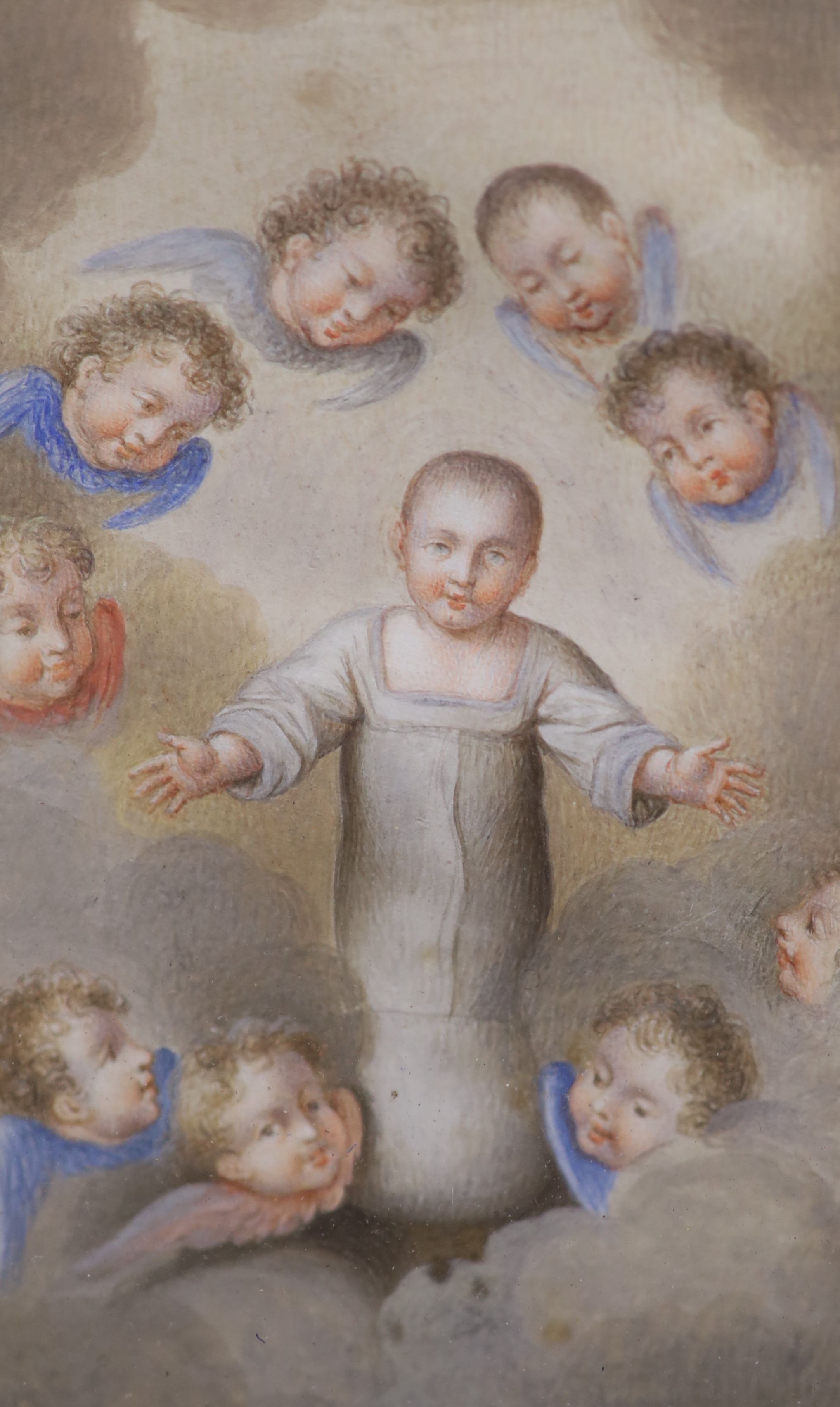 A watercolour on vellum, Christ in swaddling clothes attended by angels, label reads Italian 1620, 9 x5.5cm.